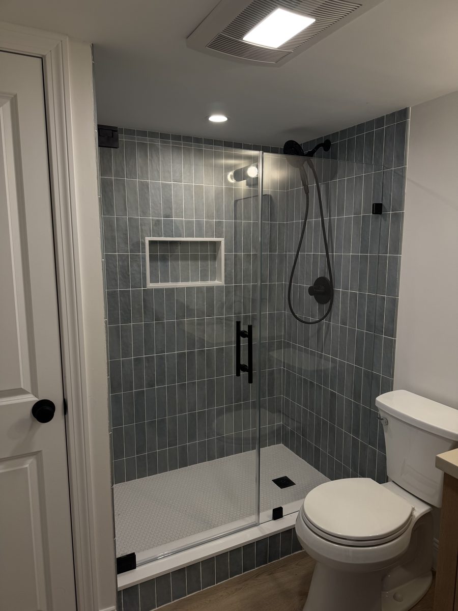 frameless shower door with matte black hardware installed in Peabody MA bathroom