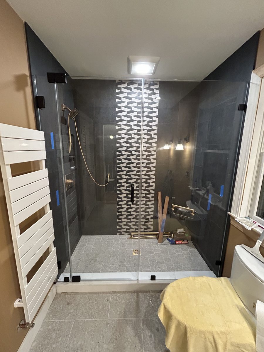 frameless alcove shower door matte black hardware geometric tile North Shore Massachusetts