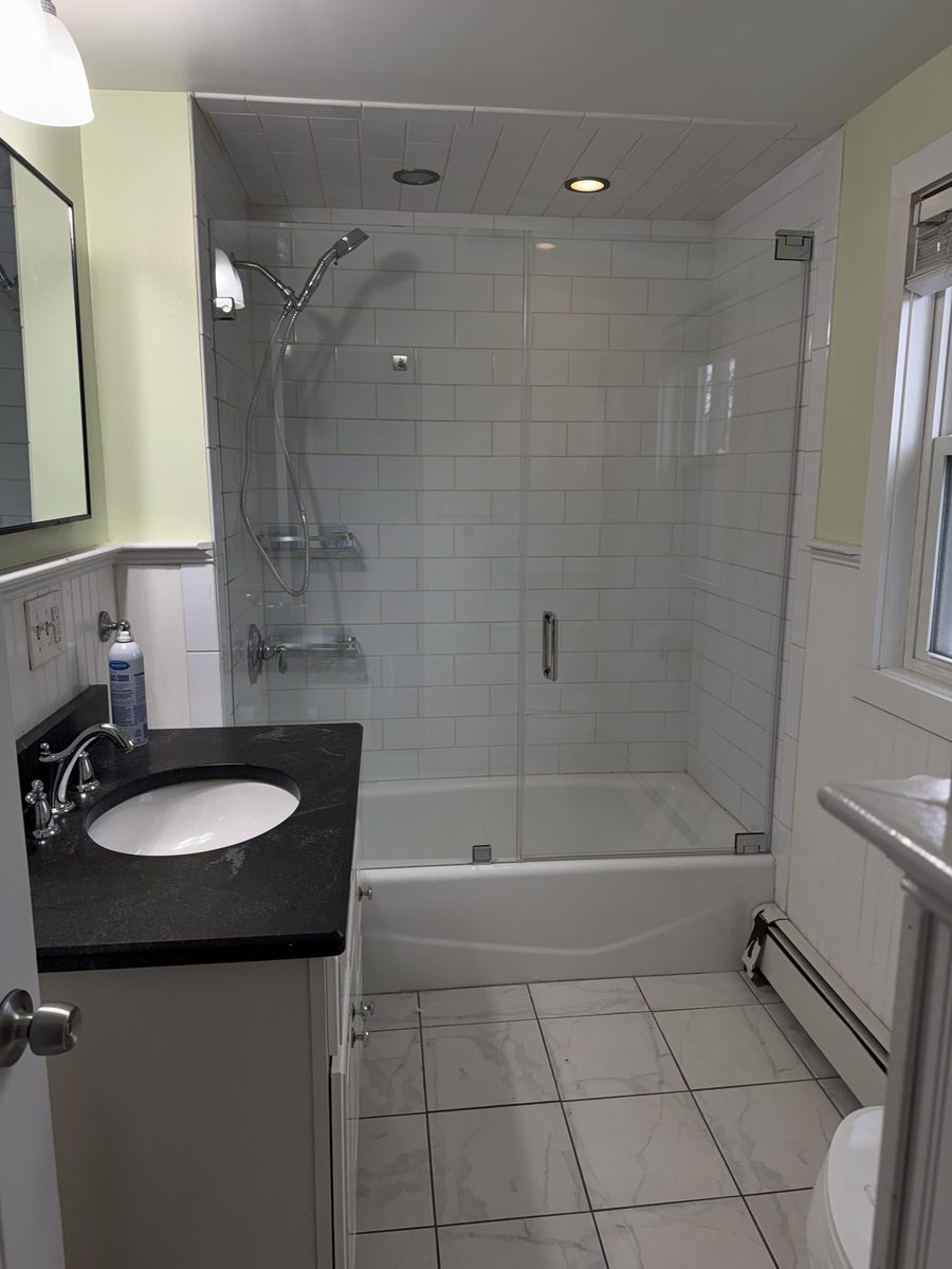 semi-frameless tub enclosure chrome hardware white subway tile North Shore MA installation