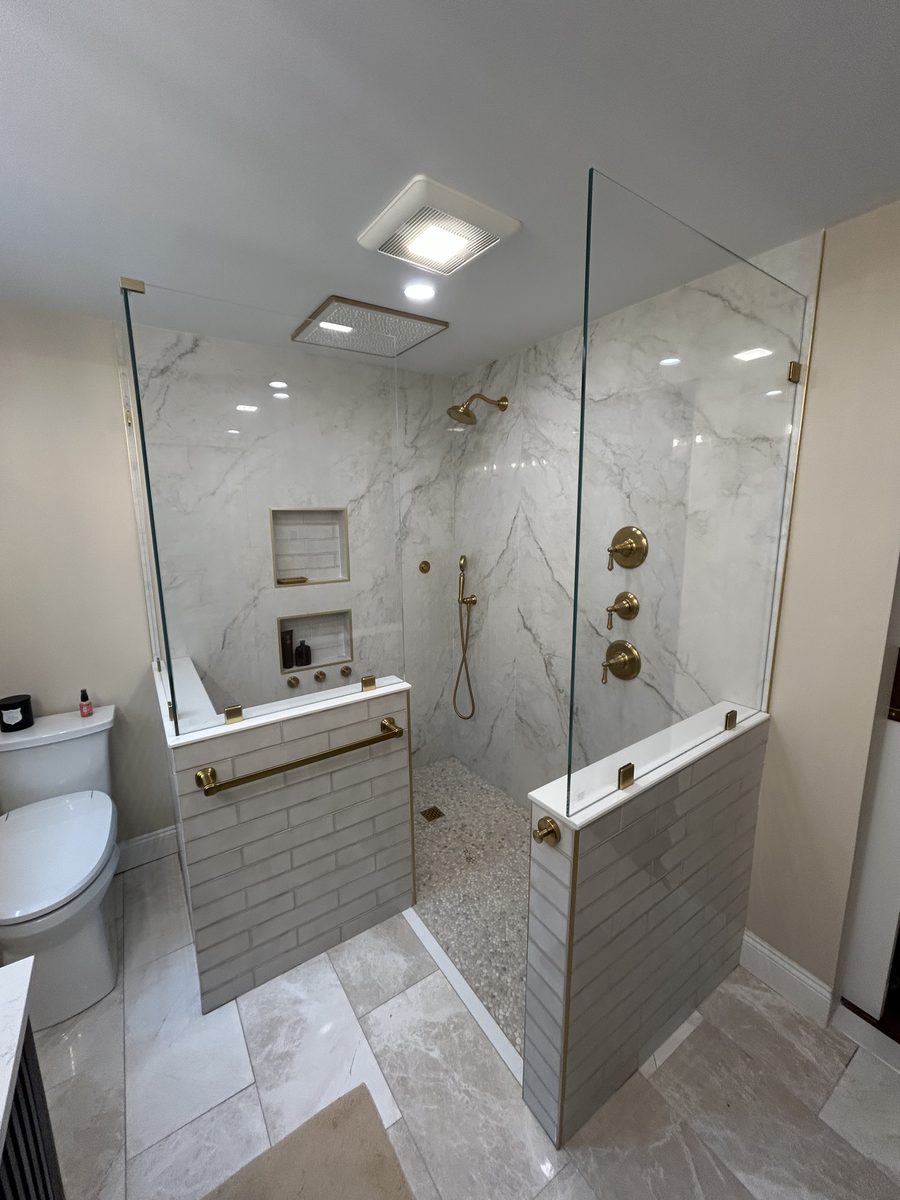 frameless walk-in shower enclosure brushed gold hardware marble walls Peabody Massachusetts