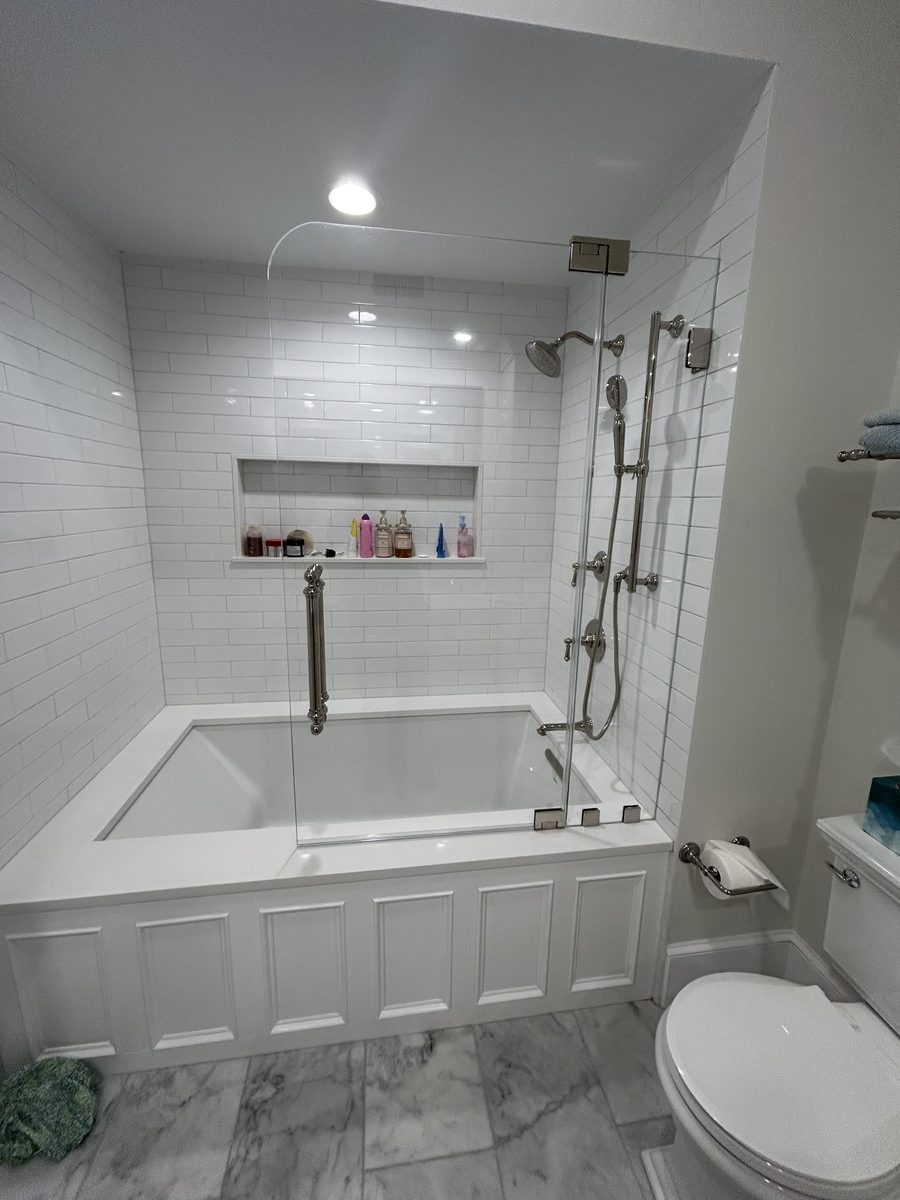 frameless pivot tub door brushed nickel hardware white subway tile North Shore MA